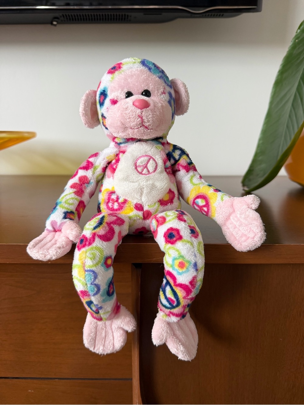 Douglas plush monkey in a colorful peace & flower print